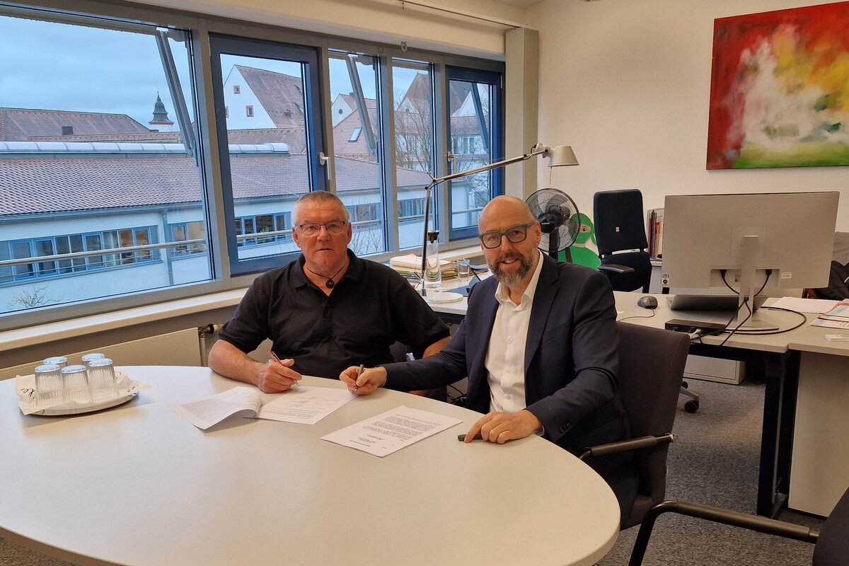 Unterzeichnung der Vereinbarung durch den Vorstandsvorsitzenden von Ingolstadt e.V. Fred Over (l.) sowie den Leiter des Amts für Jugend und Familie Oliver Betz.